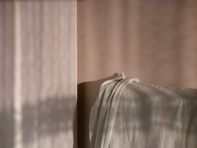Soft light falling across draped linen and a quiet wall